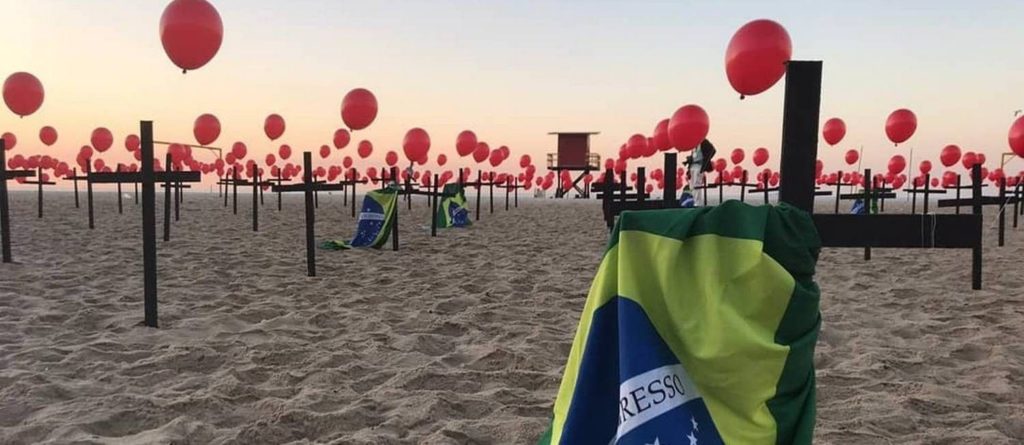 A ONG Rio de Paz levou balões de gás vermelhos e cruzes em Copacabana para lembrar os quase 100 mil mortos pela Covid-19 no Brasil 