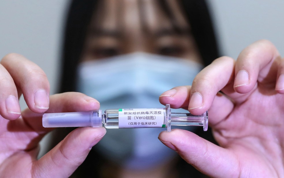 Funcionária exibe amostra de possível vacina contra a Covid-19 desenvolvida pela SinoPharm, em Pequim, na China — Foto: Zhang Yuwei/Xinhua via AP